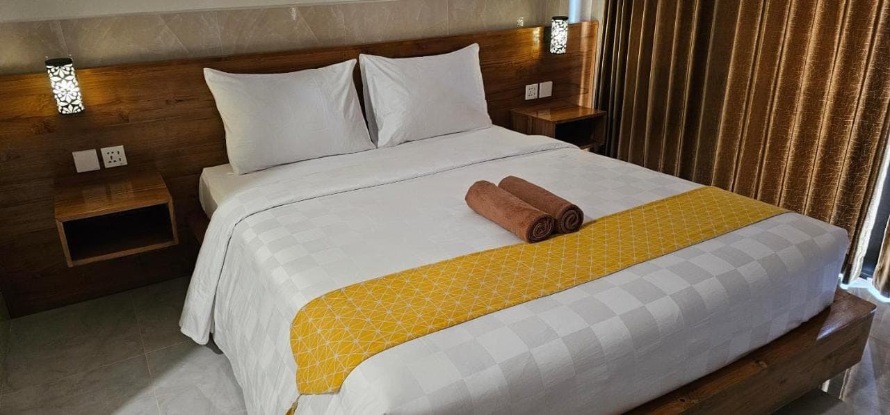 a bedroom with a large bed with two pillows at Jepun Segara Guest House in Kuta