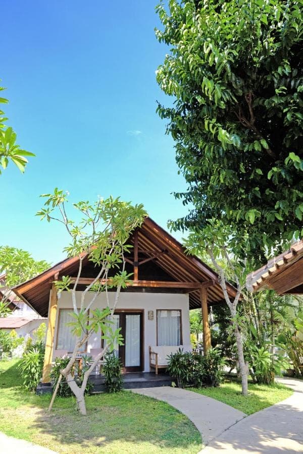 a small house with a wooden roof at Kashantee Village in Seminyak