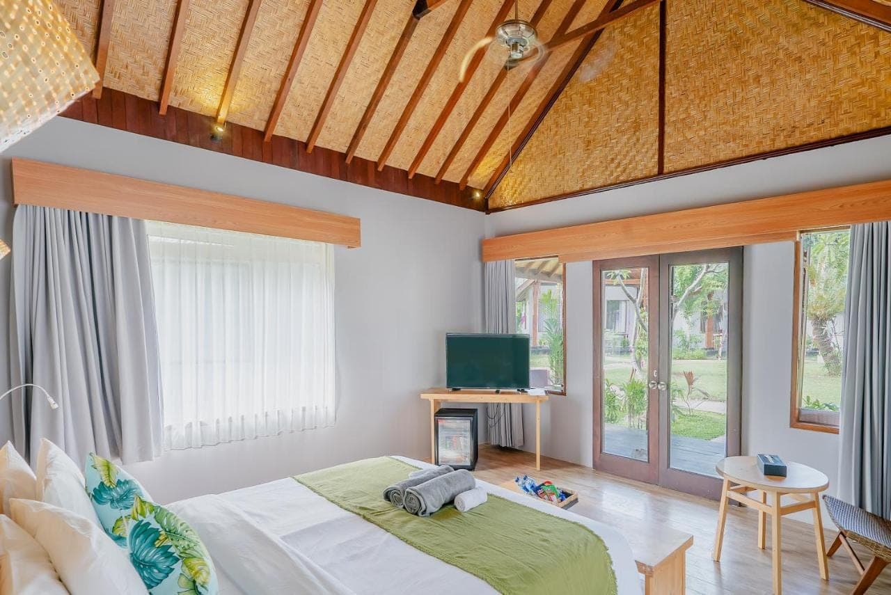 a bedroom with a bed and a tv in it at Kashantee Village in Seminyak
