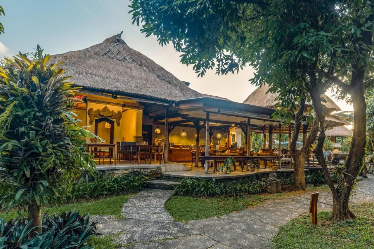 a resort with a restaurant with tables and chairs at Sri Phala Resort &amp; Villa in Sanur