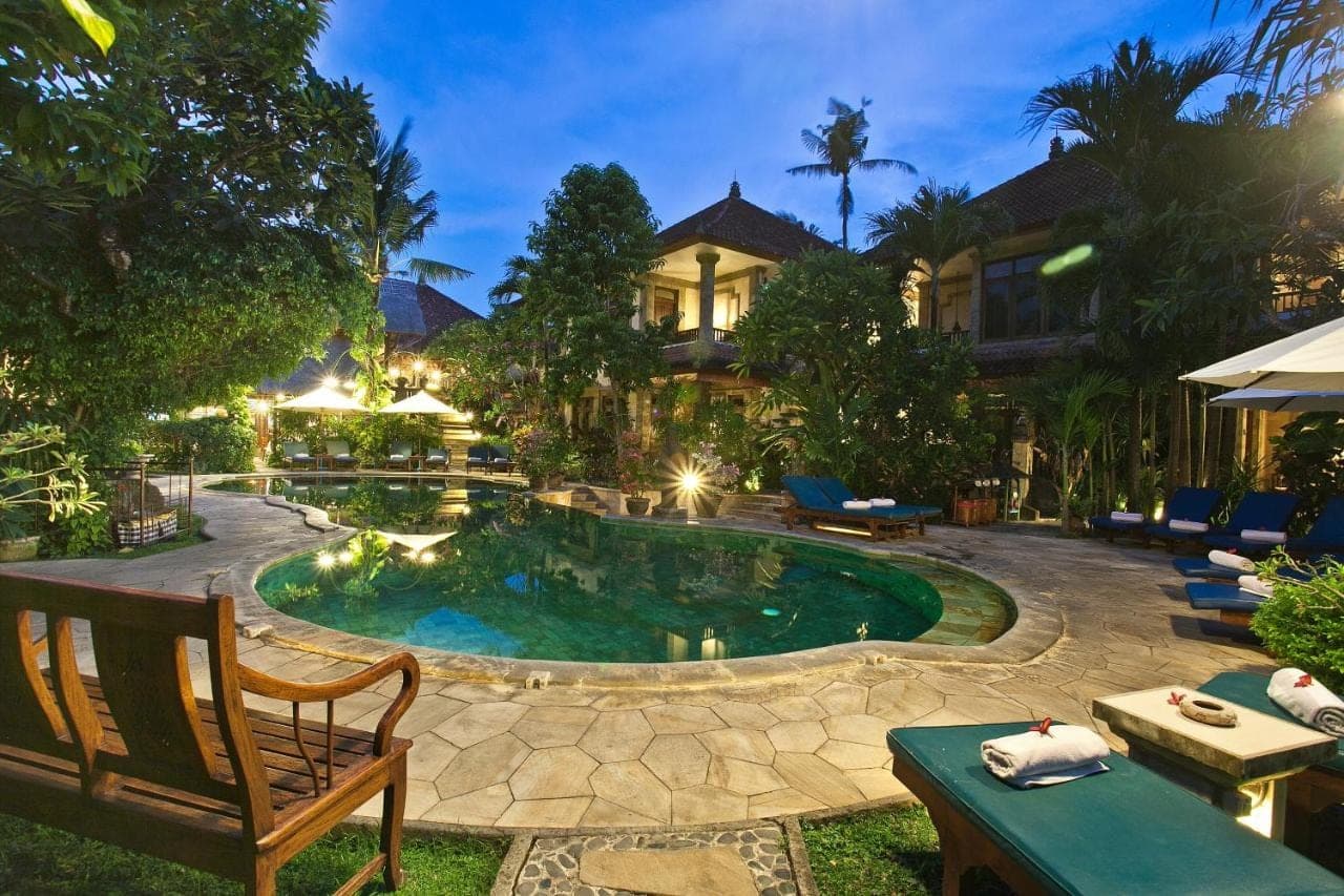 a backyard with a pool and a house at Tamukami Hotel in Sanur