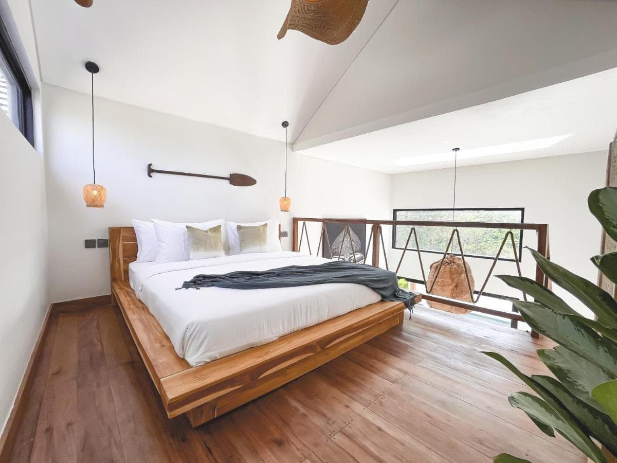 a bedroom with a bed and a balcony at CARI Surf Camp &amp; Studio's in Uluwatu