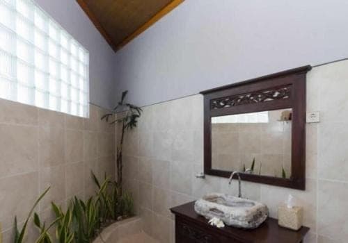 a bathroom with a sink and a mirror at Baliku Dive Resort in Amed