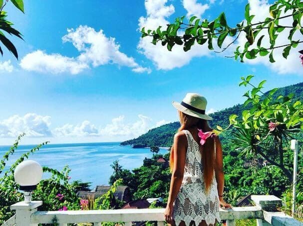 a woman in a hat looking at the ocean at Baliku Dive Resort in Amed
