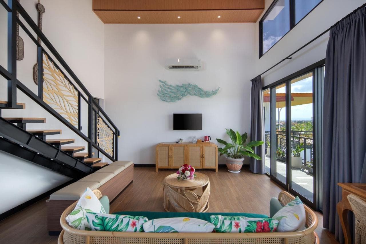 a living room with a staircase and a couch at Amandaya Canggu in Canggu