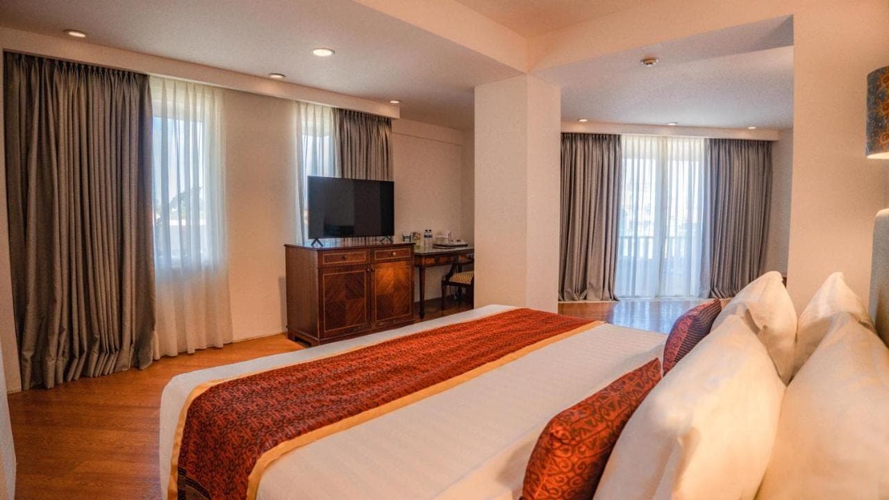 a hotel room with a large bed and a television at Kuta Paradiso Hotel in Kuta