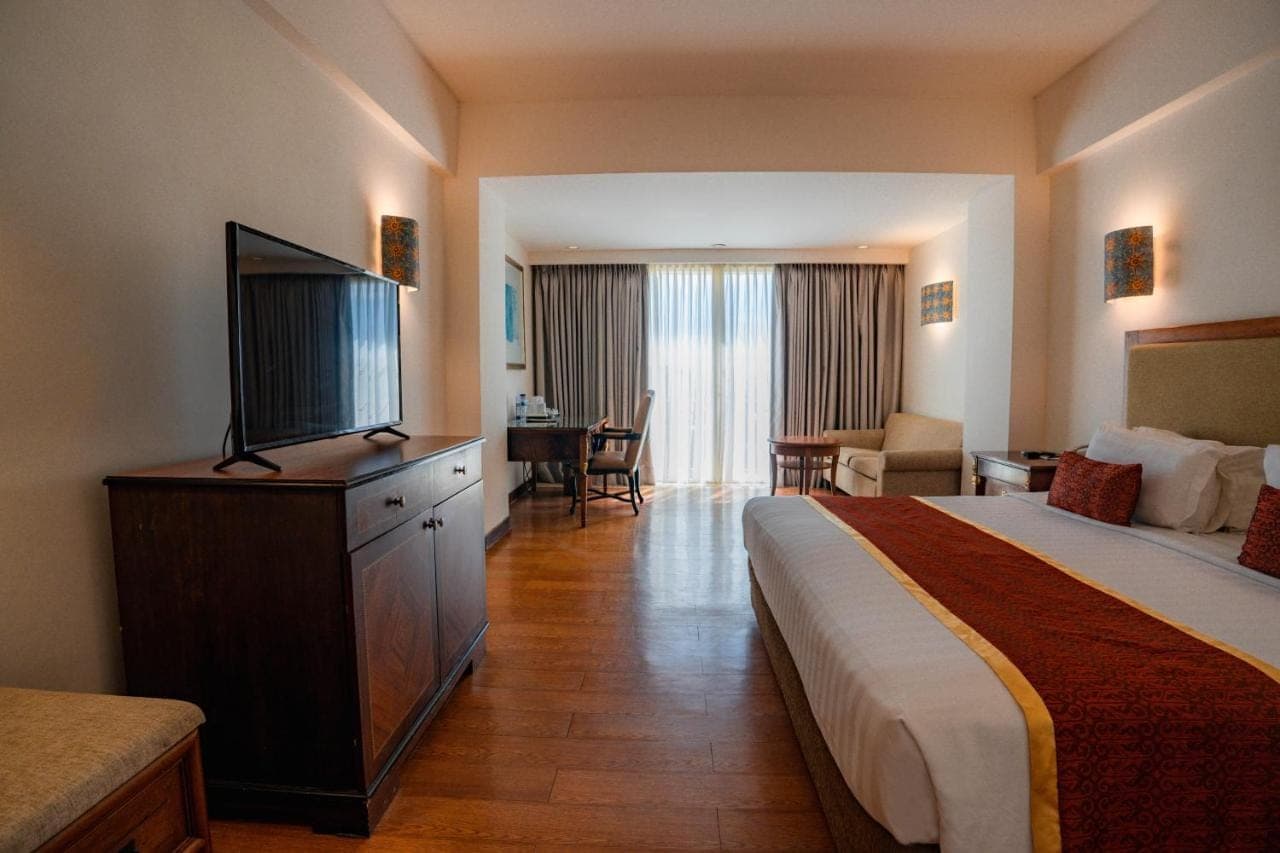 a hotel room with a bed and a flat screen tv at Kuta Paradiso Hotel in Kuta