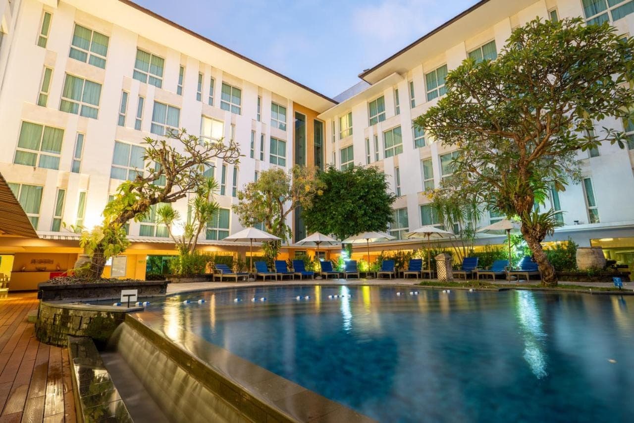 a hotel swimming pool in front of a building at Bintang Kuta Hotel in Kuta