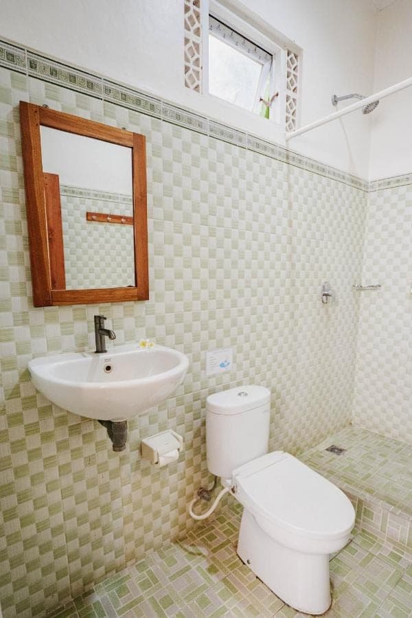 a bathroom with a toilet and a sink at Kayuma House Canggu in Canggu