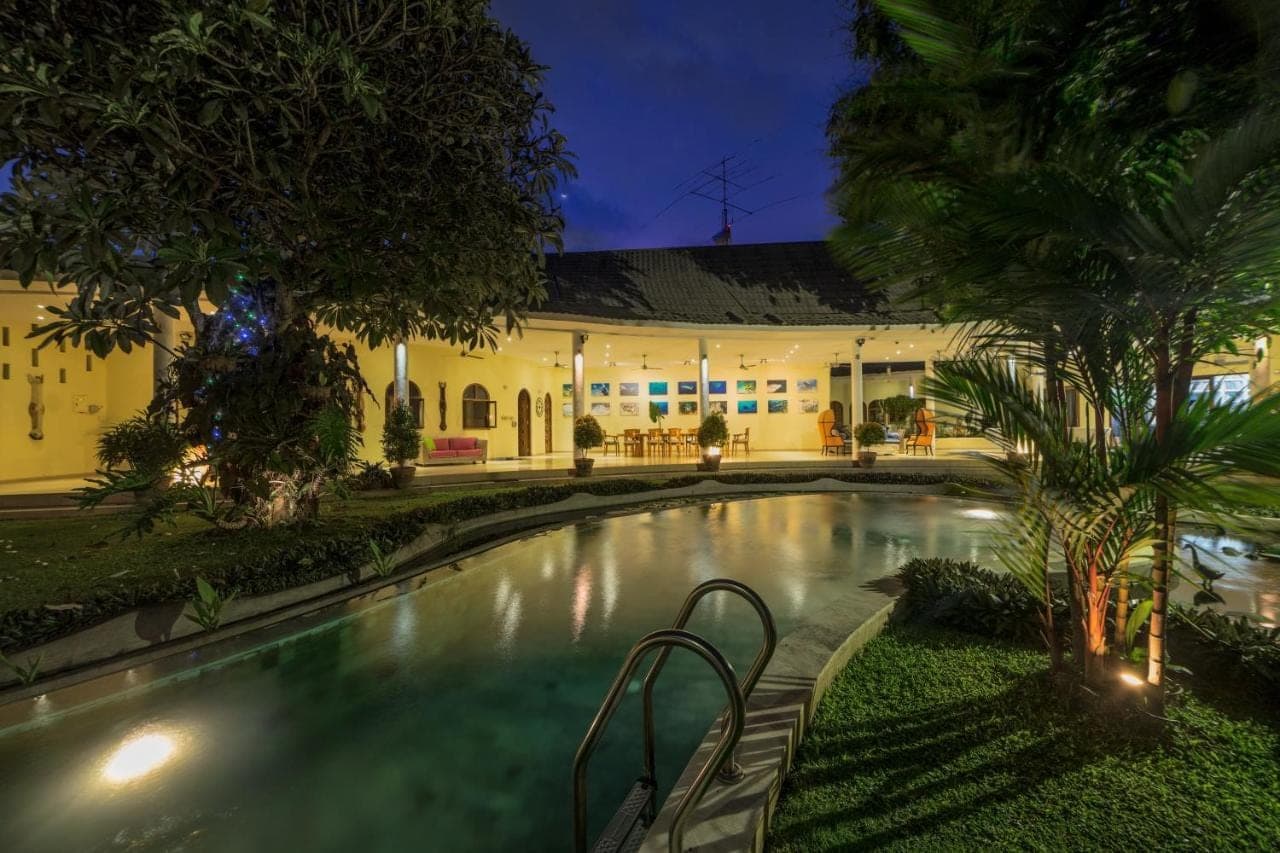a swimming pool in front of a building at Villa Costa Sanur in Sanur