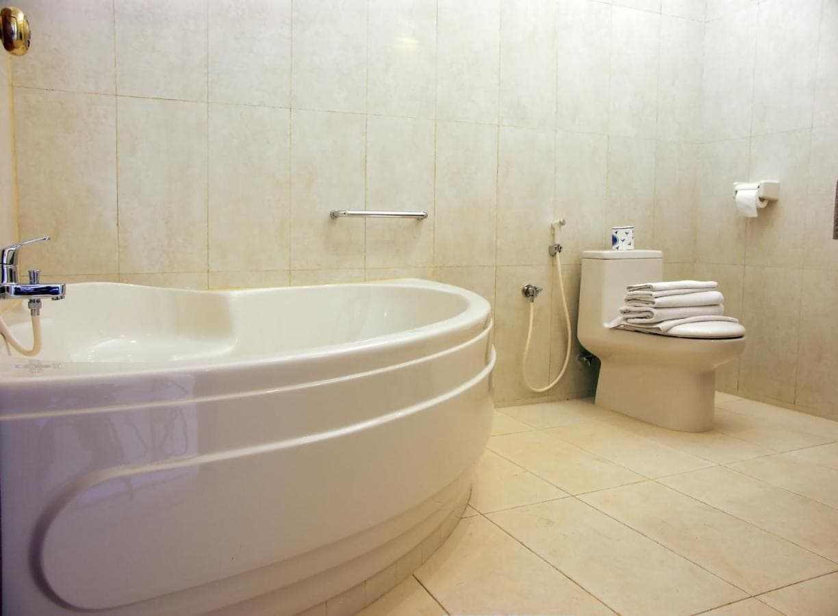 a bathroom with a white tub and a toilet at Febri's Hotel &amp; Spa in Kuta