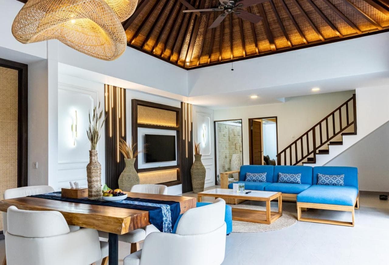 a living room with a blue couch and a table at Lalasa Villas Canggu in Canggu