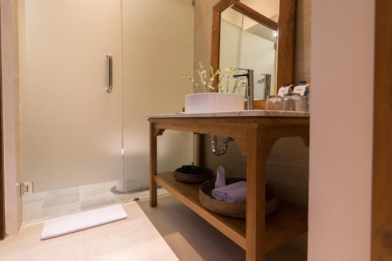 a bathroom with a sink and a vanity with a mirror at Ulun Ubud Resort &amp; Spa in Ubud
