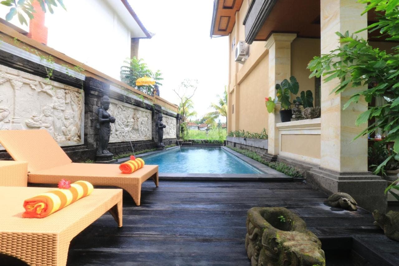 a swimming pool in the middle of a building at Frangipani Bungalow in Ubud
