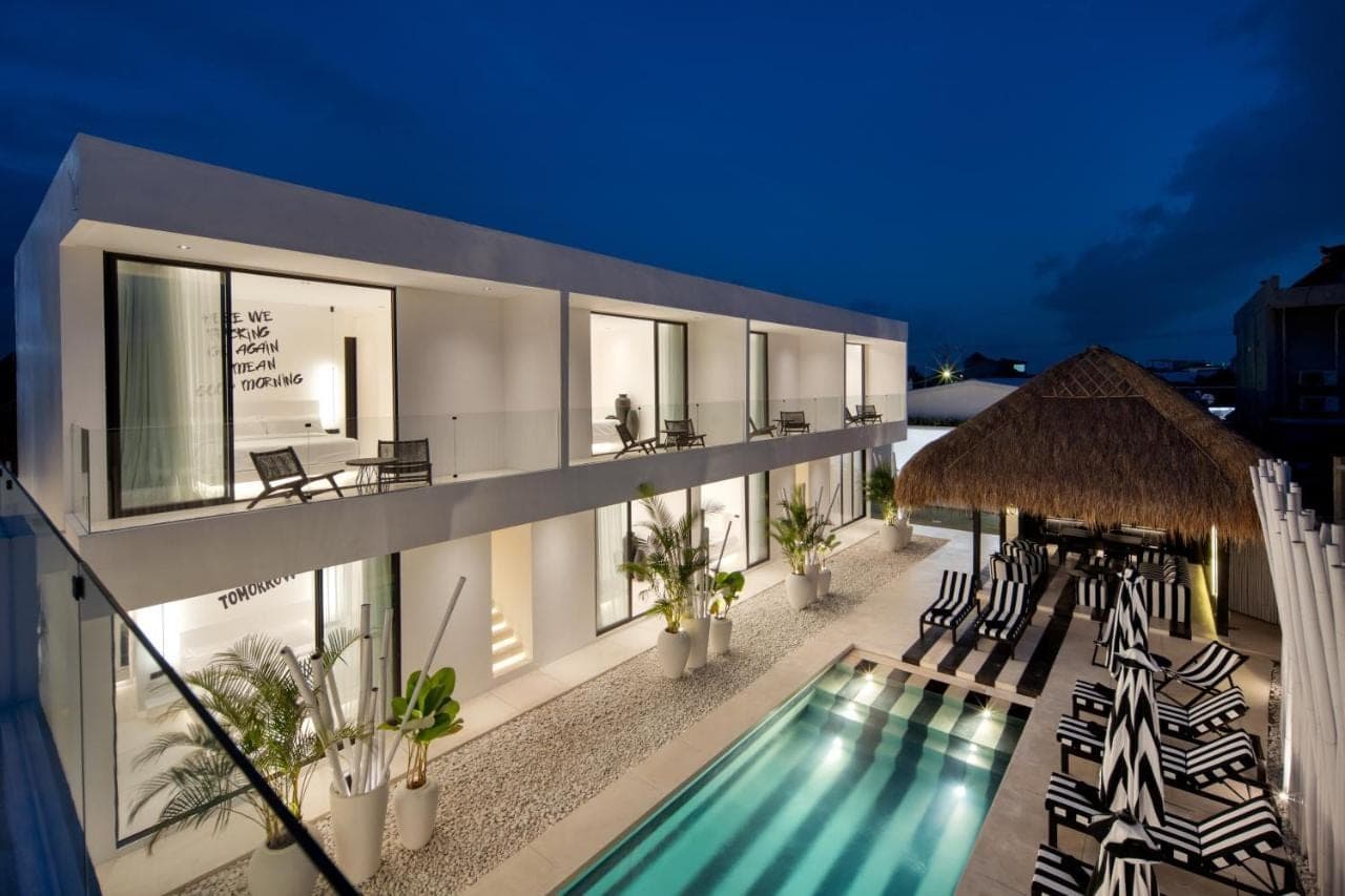 a villa with a swimming pool at night at The Den Canggu in Canggu