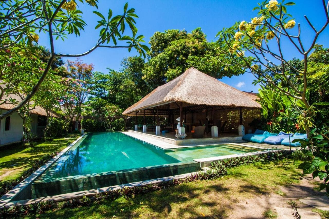 a villa with a swimming pool and a gazebo at Blind Dog Inn in Sanur