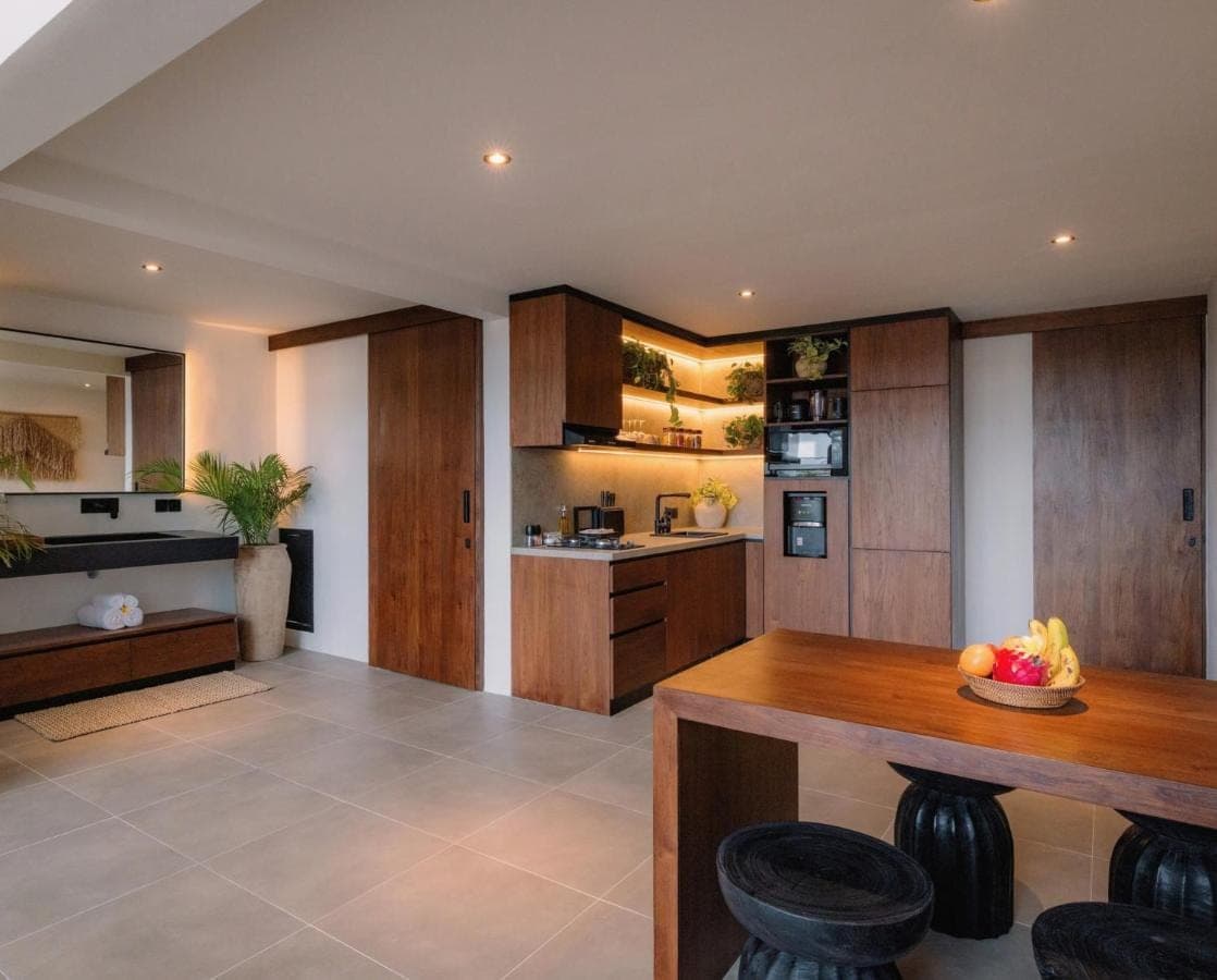 a kitchen with wooden cabinets and a wooden table at Arya Wellness - female only in Ubud