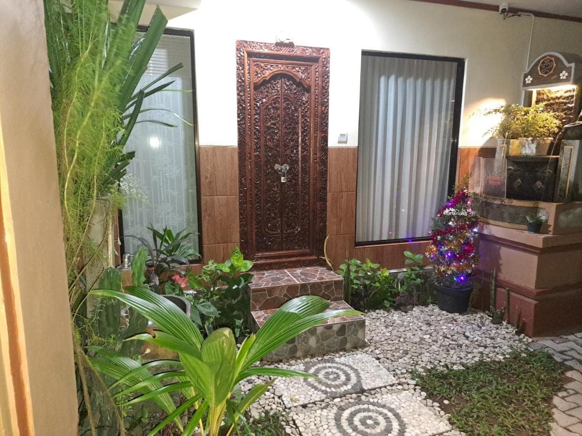 a room with a door and some plants at Ascarya Guest House in Sanur