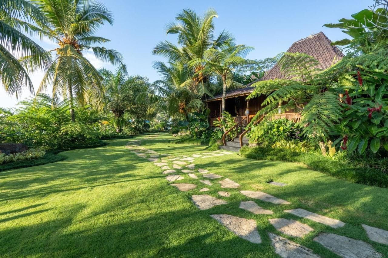a path in front of a house with palm trees at Ubud Valley Boutique Resort in Ubud