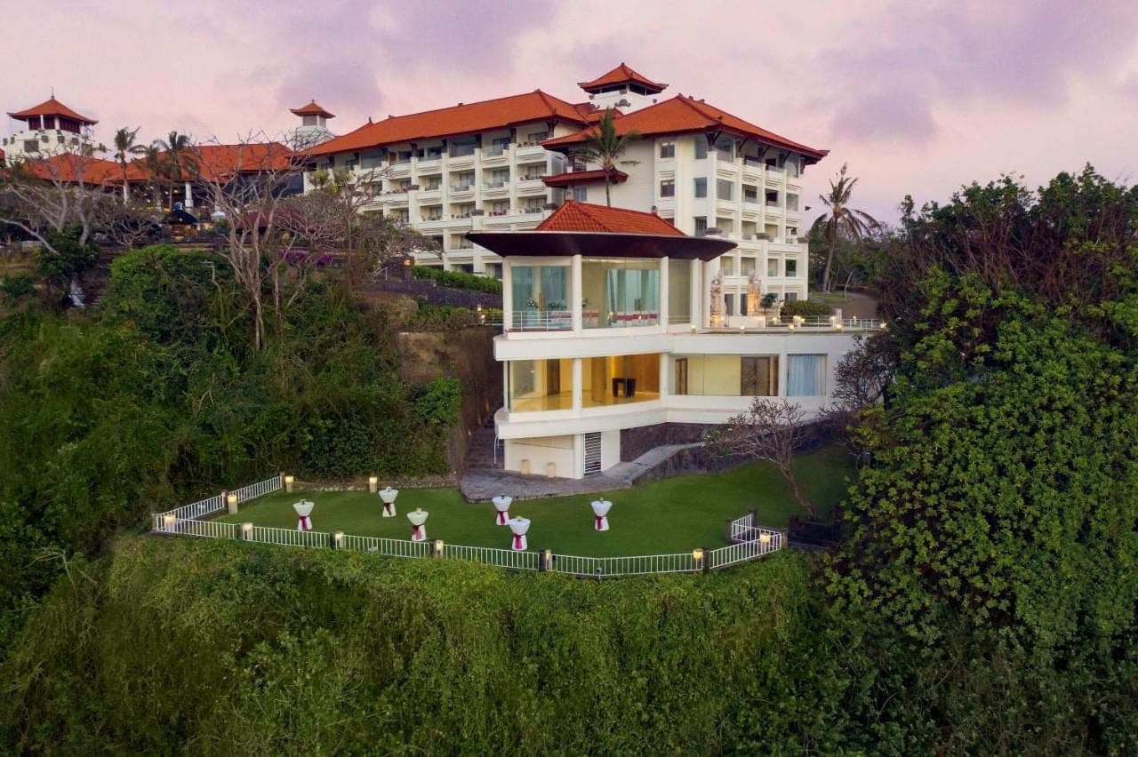 a building on a hill with a lawn in front of it at Hilton Bali Resort in Nusa Dua
