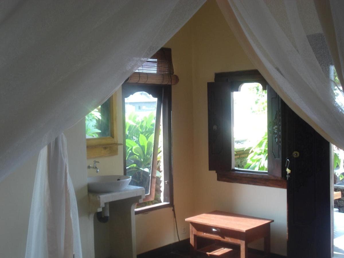 a bathroom with a sink and two windows at Bulih Beach Bungalows in Amed
