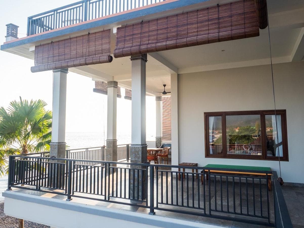 a balcony of a house with a view of the ocean at Amed Beach Villa in Amed