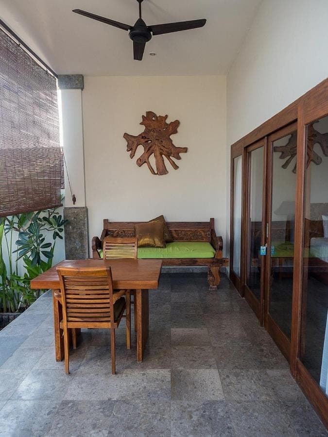 a dining room with a table and a couch at Amed Beach Villa in Amed