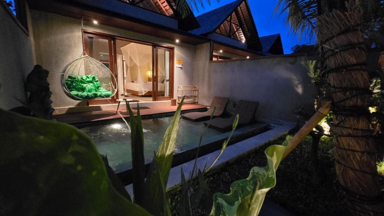 a villa with a swimming pool at night at Arena Villa Ubud in Ubud