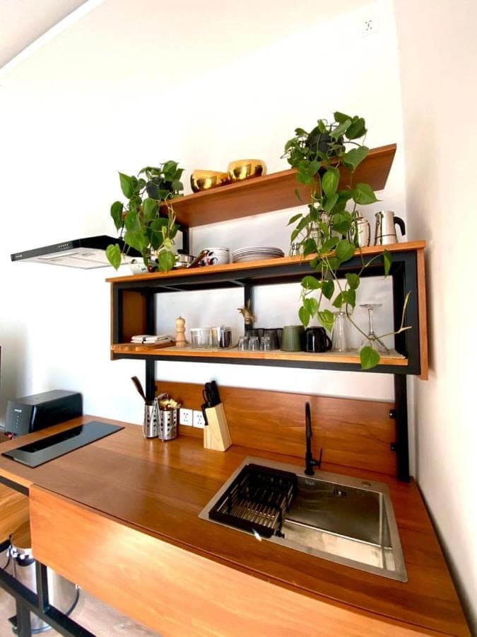 a wooden desk with a keyboard and some plants at Tirta Loft in Canggu