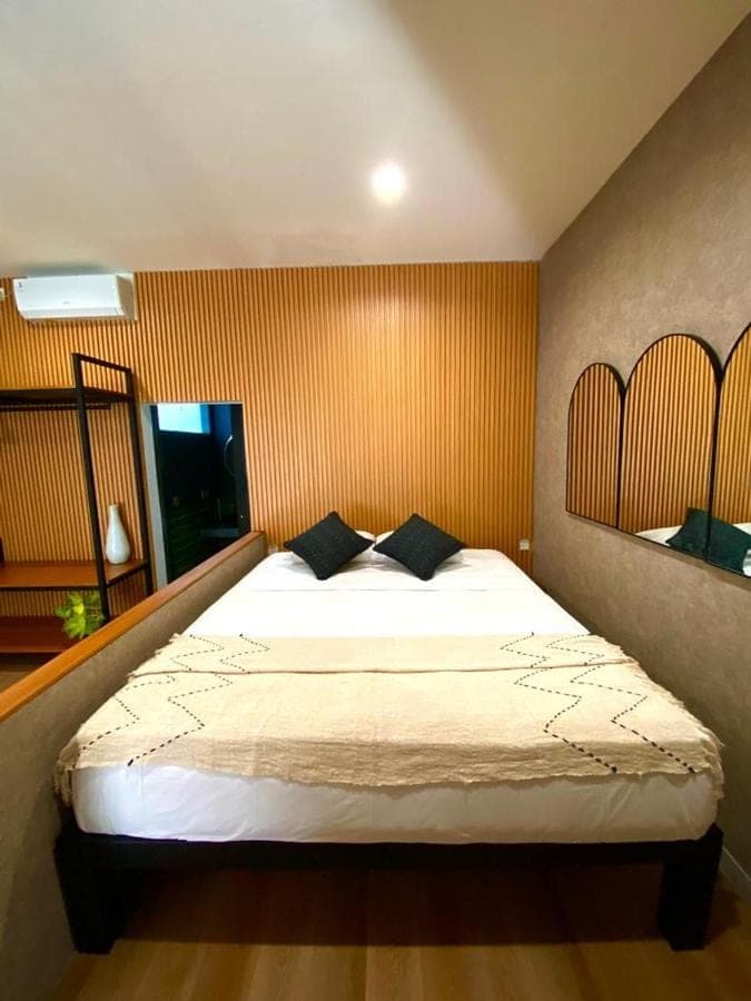 a bedroom with a large bed with two pillows at Tirta Loft in Canggu