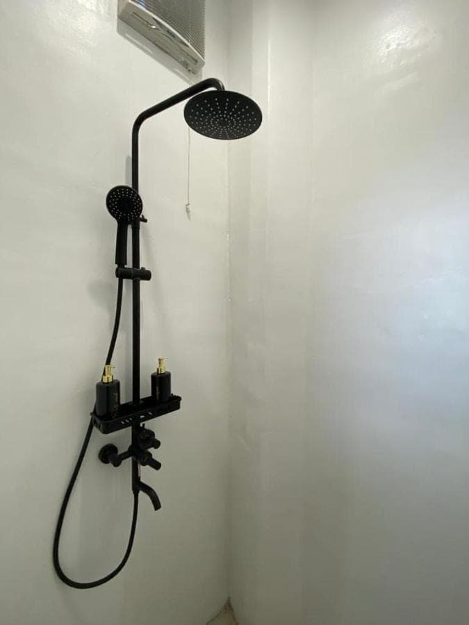 a black lamp on a wall in a room at Tirta Loft in Canggu