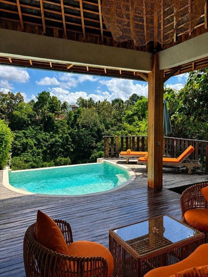 a view of a swimming pool from the deck of a house at Les Mandarines - Rice fields &amp; jungle retreat in Ubud