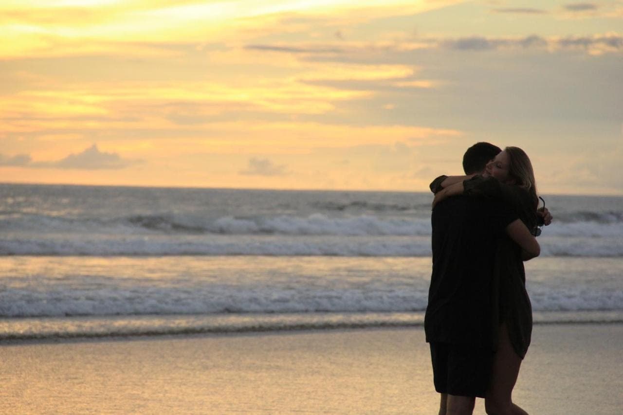 a couple kissing on the beach at sunset at The Wolas Villas in Seminyak