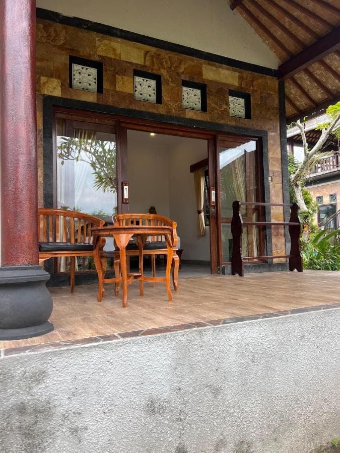 a wooden table and chairs on a patio at Giri Carik in Sidemen