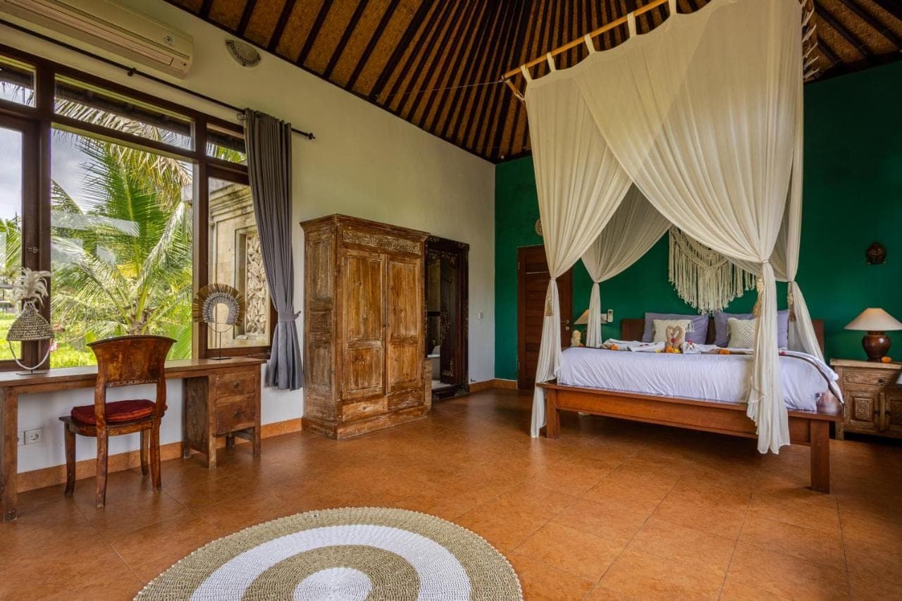 a bedroom with a bed with a canopy at beautiful villa - ricefield view - private pool in Ubud