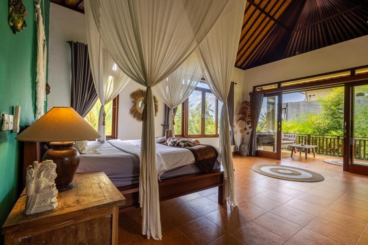 a bedroom with a bed with a canopy at beautiful villa - ricefield view - private pool in Ubud