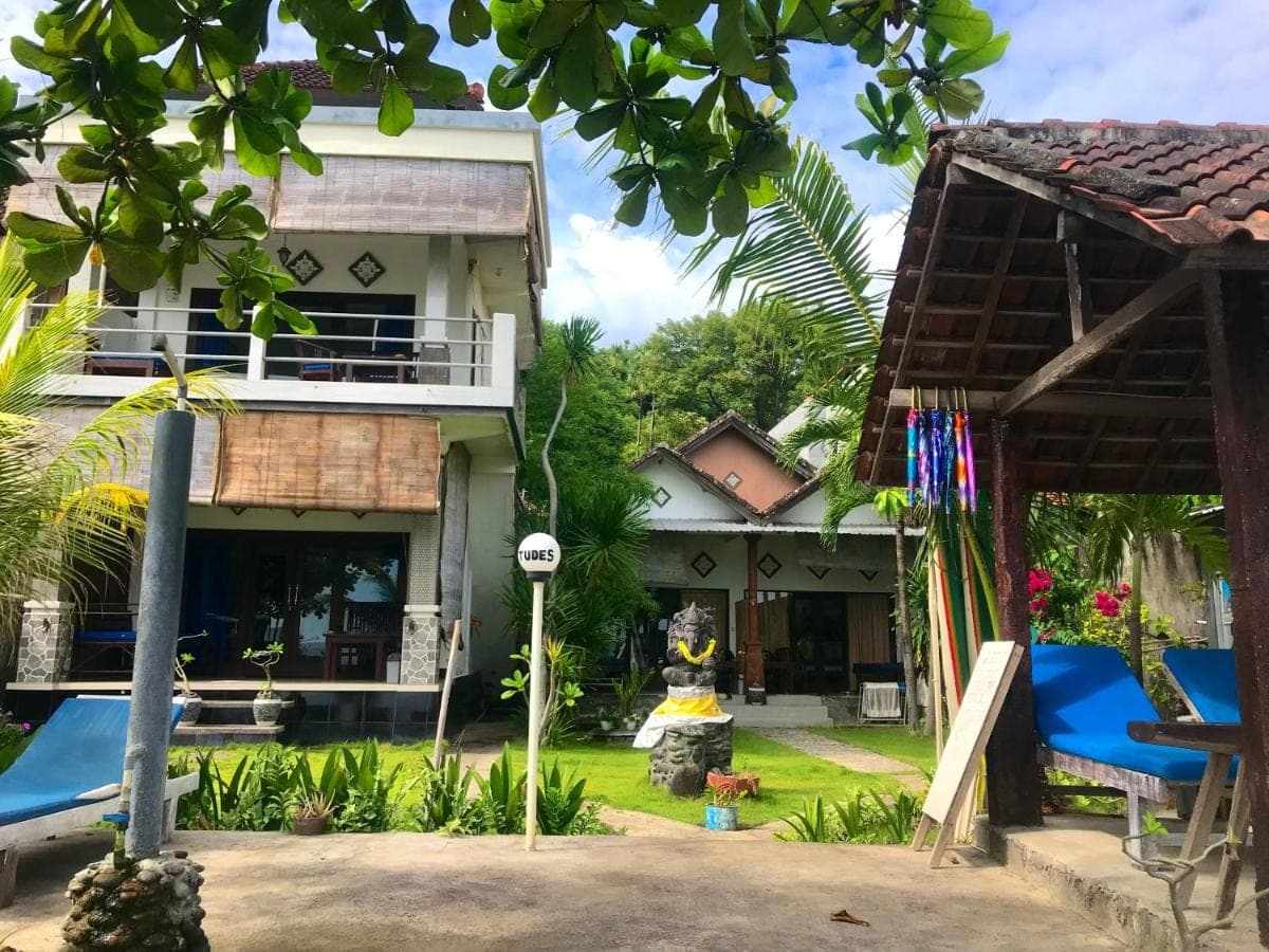 a house in the middle of a yard at Tudes Homestay in Amed