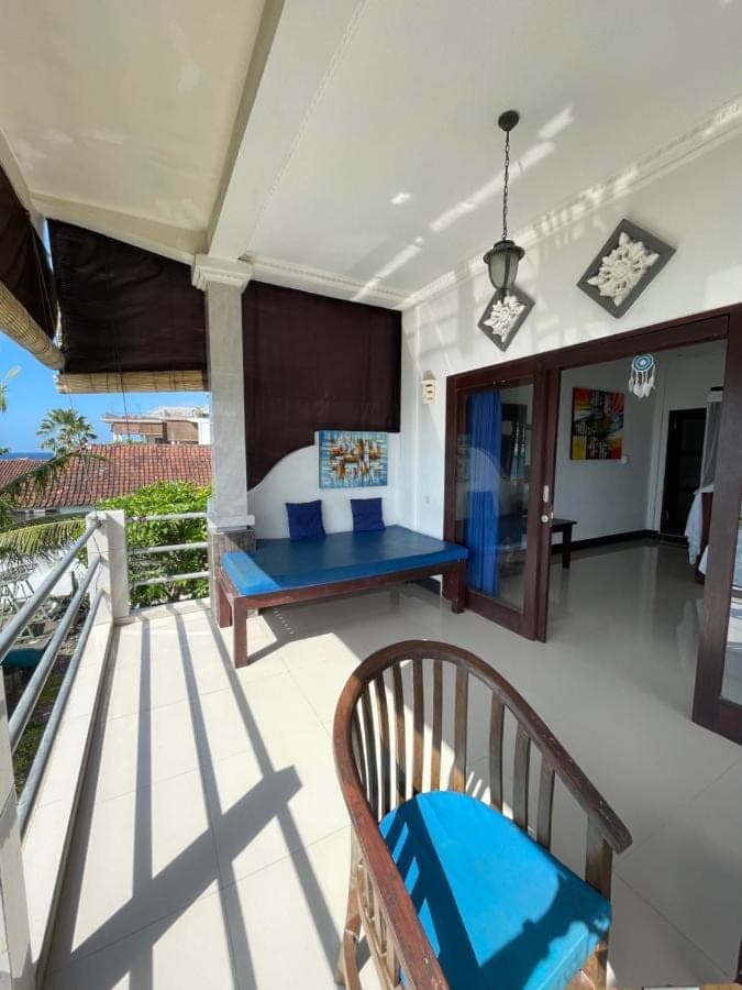 a room with a balcony with a blue bench at Tudes Homestay in Amed