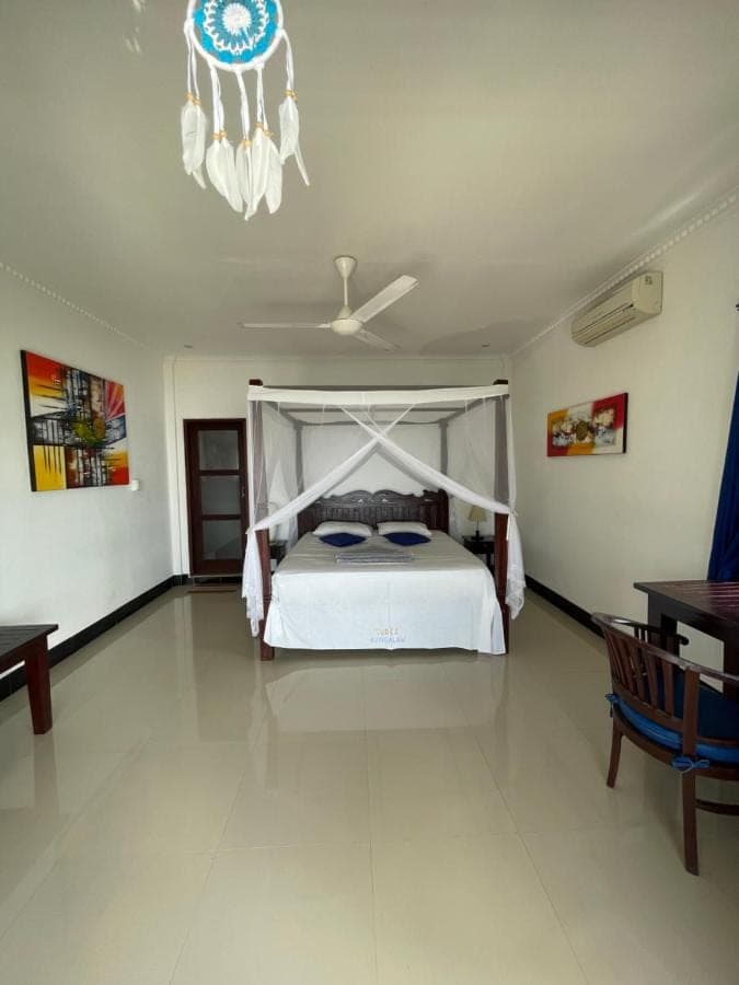 a bedroom with a bed and a chandelier at Tudes Homestay in Amed