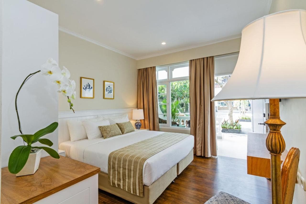 a bedroom with a bed and a large window at Akaya Bali in Sanur