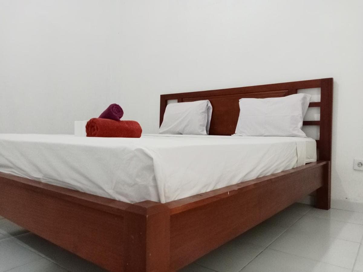 a bed with a red stuffed animal sitting on it at KOMANG homestay in Amed