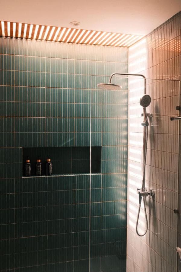 a bathroom with a shower with green tiles at Jisa Sidemen in Sidemen