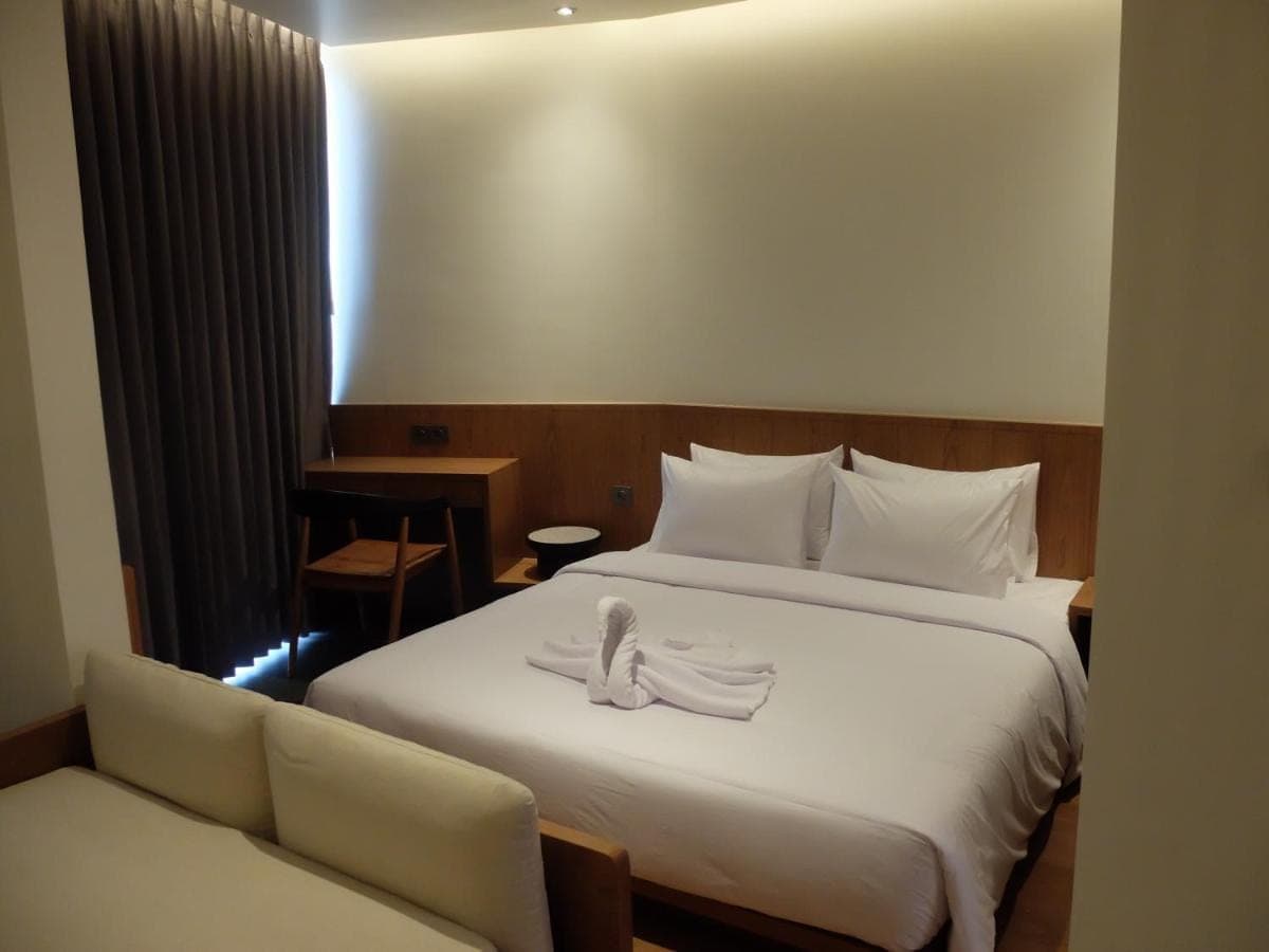 a hotel room with a bed with a swan on it at The Fields Hotel and Apartment in Seminyak