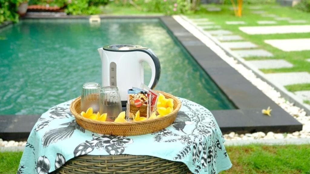 a basket of food on a table next to a pool at Kubu Green in Nusa Dua