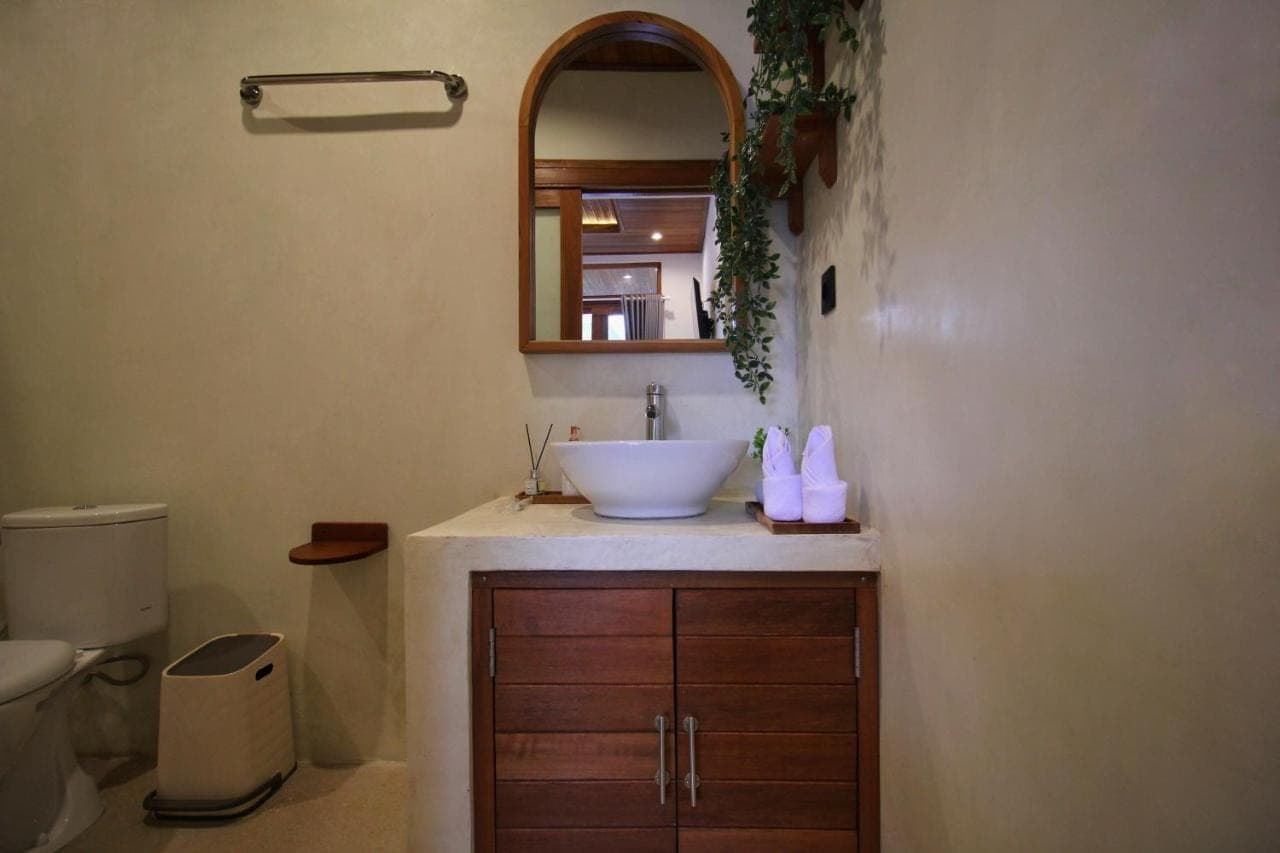 a bathroom with a sink and a toilet at Umah Pulu Bisma in Ubud