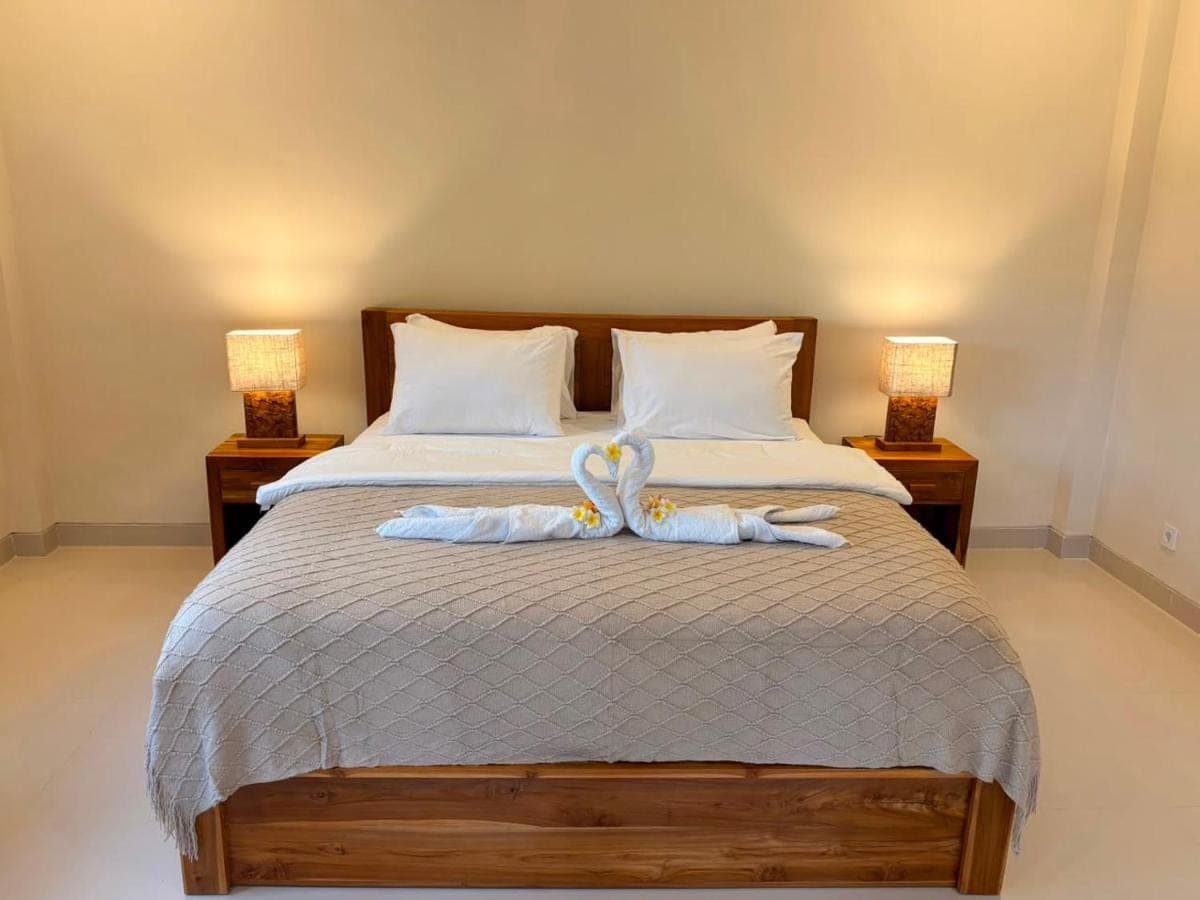 a bedroom with a bed with swans on it at Kayana Amed in Amed
