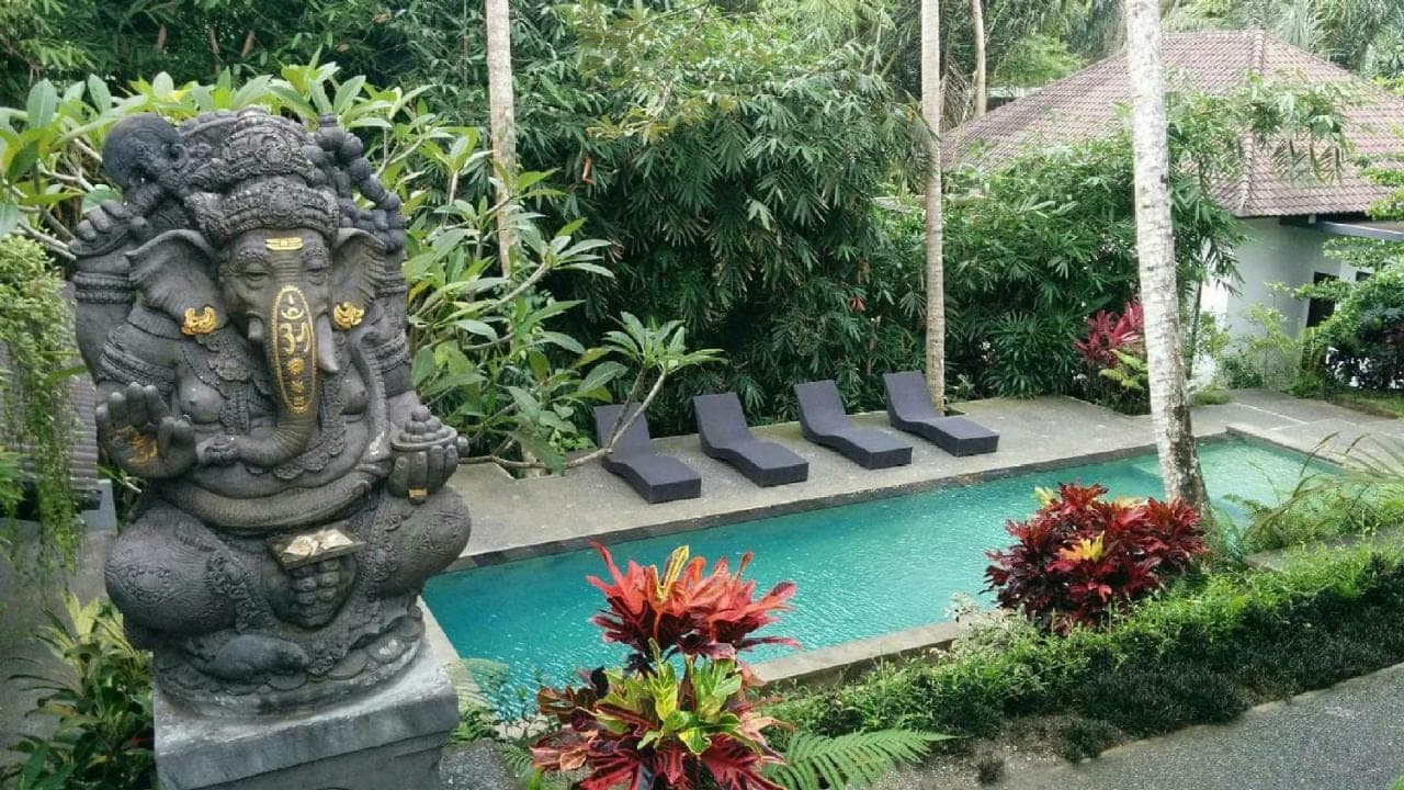a statue of an elephant next to a swimming pool at The Bali Shanti in Ubud