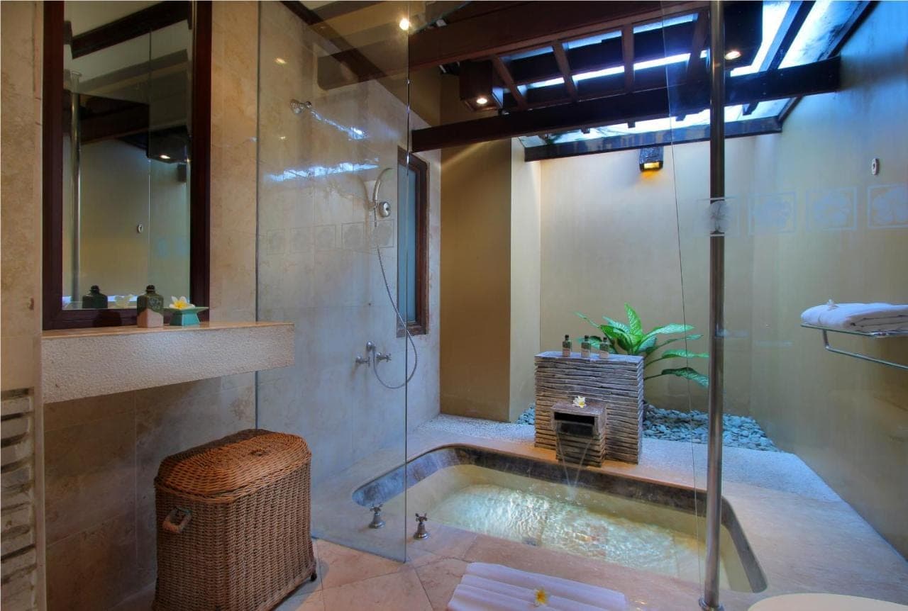 a bathroom with a shower and a tub with a sink at AlamKulkul Boutique Resort in Kuta