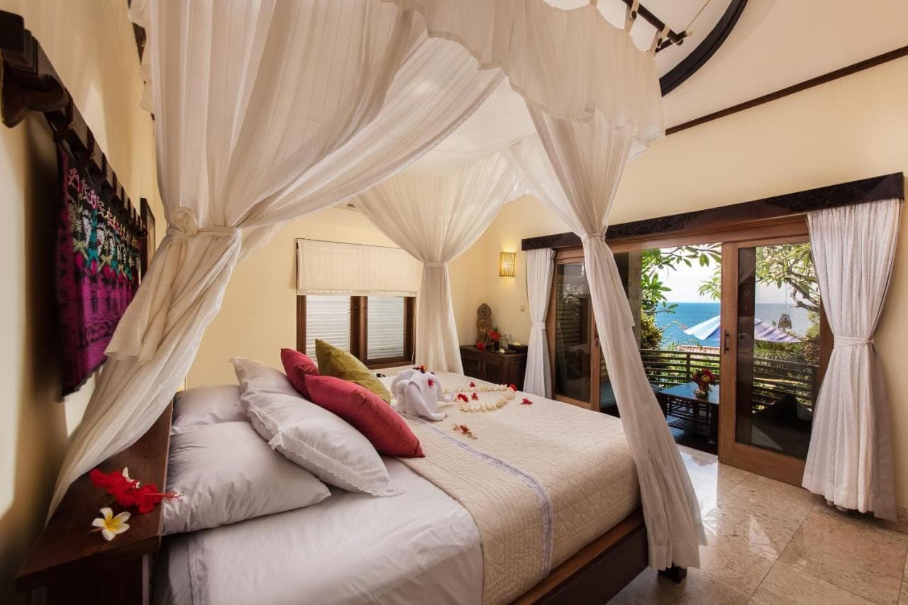 a bedroom with a bed with a canopy at Blue Moon Villas Resort in Amed