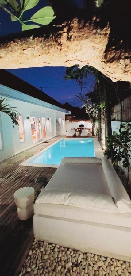 a swimming pool in front of a house at Love Song Villa Canggu in Canggu